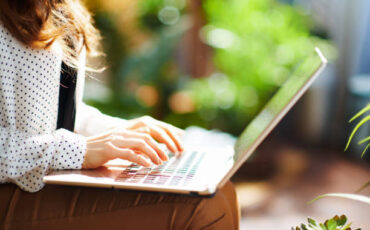Green Home. Closeup on middle aged woman with laptop in the living room in sunny day.